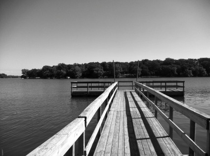 A dock with a pier and railing in the water.